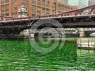 View of Chicago River after being dyed green for St. Patrick& x27;s Day, with snow showers coming down Stock Photo