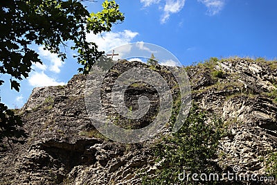 View of a Christian cross placed on top of a rock Stock Photo