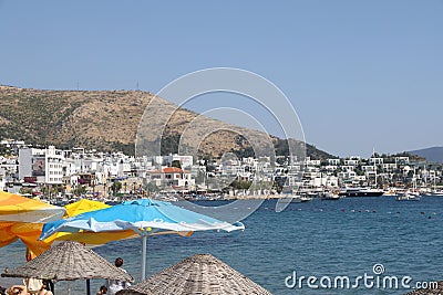 View of the city beach of Bodrum with beach umbrellas on the background of yachts, Marmaris, Turkey, May 2023. Editorial Stock Photo