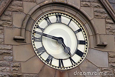 Large clock face in stone wall of building Stock Photo