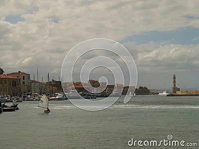 View of the coastline and the bay on which sails the yacht with a white sail, Chania Editorial Stock Photo