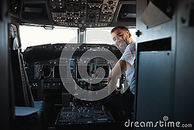 Mirthful experienced pilot looking happy at his workplace Stock Photo