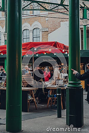 View through the columns of people at a cheese stand inside Borough Market, London, UK Editorial Stock Photo