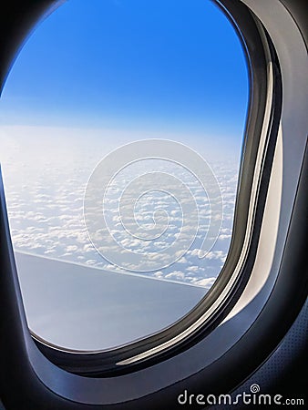 View of a commercial aeroplane from window where you can see the wing which flies above the clouds. Stock Photo