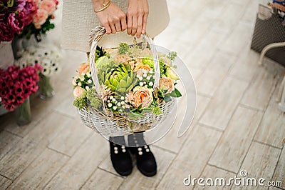 view of composition of different fresh flowers in white wicker basket in female hands Stock Photo