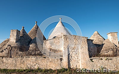 View of the conical dry stone roofs of a group of trulli houses outside Alberobello in Puglia Italy Editorial Stock Photo