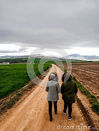 View of couple walking on a dirt road in beautiful parkland Editorial Stock Photo