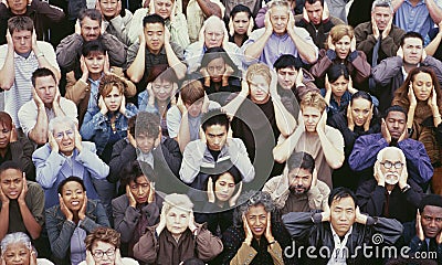 View of crowd covering ears Stock Photo