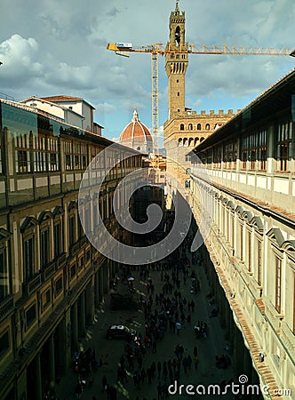 View of the crowded courtyard from the windows of Uffizi Gallery with a construction crane, the Cathedral dome and clock tower of Editorial Stock Photo