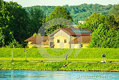 View of Danube river bank, Donaupark in Linz, Upper Austria, vibrant green color, golden sun rays, mountain panorama in the backgr Stock Photo