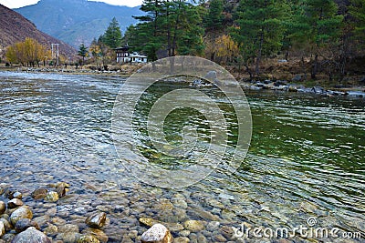 View of the densely packed dwellings on the banks of river Paro Chu in Thimphu, Bhutan. Paro is the second largest city In Bhutan Stock Photo