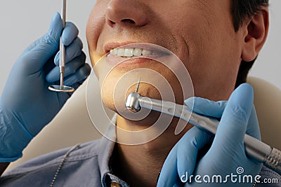 View of dentist in latex gloves holding dental instruments near cheerful patient Stock Photo