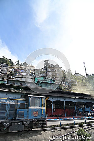 View of diesel locomotive and houses built on the hillside, along the Darjeeling Himalayan Railway, West Bengal, India Editorial Stock Photo