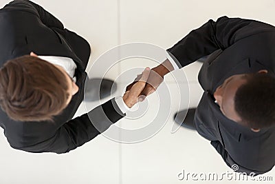 View directly from above diverse businessmen in suits shaking hands Stock Photo