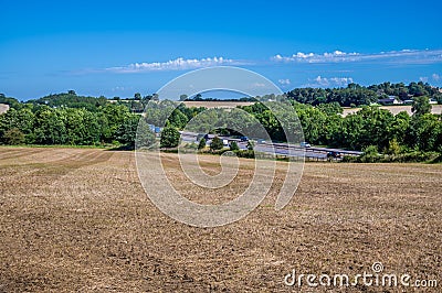 A view down a field towards the M40 motorway in Oxfordshire, UK Stock Photo