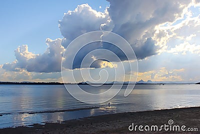 View of dramatic clouds and early sunset looking from Bribie Island over the Pumicestone Passage to the Glass Mountains in Queensl Stock Photo