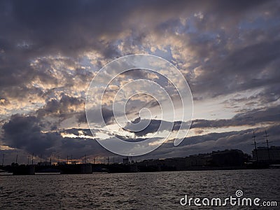 View of the dramatic sky above the sity at sunset with dark blue clouds Stock Photo