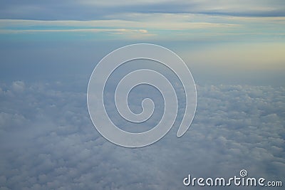 View of dreamy abstract white cloud with blue sky and sunrise light background from airplane window Stock Photo