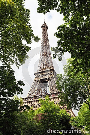 View of Eiffel Tower through summer green trees Stock Photo