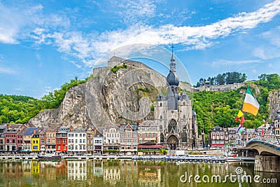 View at the embankment of Meuse river with houses and church of Our Lady Assumption in Dinant - Belgium Stock Photo