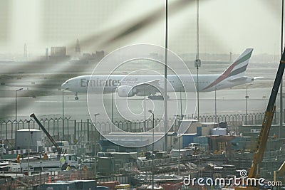 View of Emirates Airlines airplane parking on apron viewed from waiting lounge inside the terminal at Dubai Intenational Airport Editorial Stock Photo