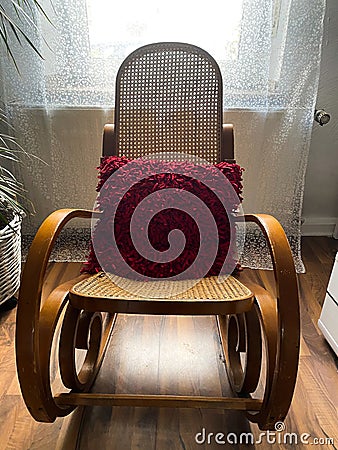 View on empty rocking chair in living room with shadow from backlight of window - grieve and loss of loved person concept Stock Photo