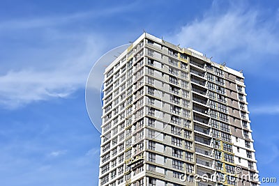 View of the facade of a new multi-storey building under construction. Suspended cradle on the facade of the skyscraper. Mobile Stock Photo