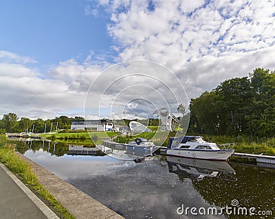 A view of the Falkirk Wheel and Visitors Complex taken from the Forth and Clyde Canal, with its moored Canal Boats. Editorial Stock Photo