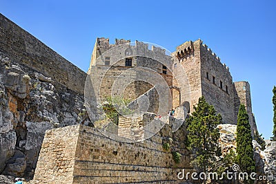 View on famous antique greek temple ruins on the rock on Greece island Rhodes in Lindos city and walking tourists. Famous sightse Stock Photo