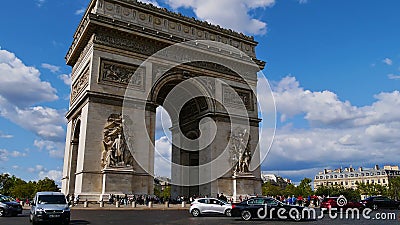 View of famous monument Arc de Triomphe with traffic on the surrounding road and crowd of tourists on sunny day in autumn. Editorial Stock Photo