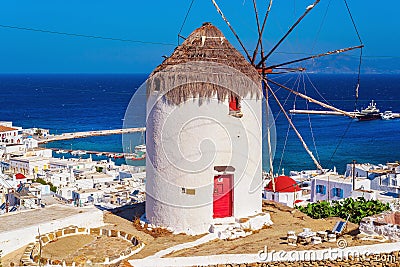 View of the famous Mykonos windmill above port and Mykonos town Stock Photo