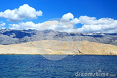 View from ferry to rocky part of Island Rab and Velebit mountain in background Stock Photo