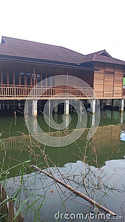 a view of a fish pond where there is a wooden house Stock Photo