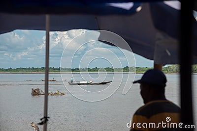 View of a fisherman`s boat with a person on the banks of the Magdalena River. Colombia. Editorial Stock Photo