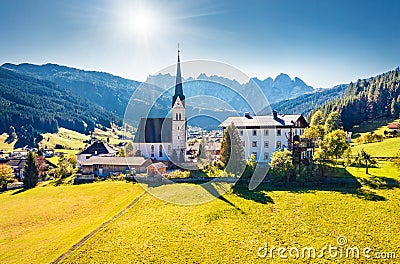 View from flying drone. Sunny morning scene of Pfarramt Catholic Church. Aerial autumn view of Gosau village in the district of Gm Stock Photo