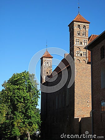 View of a fragment of a brick wall of a medieval castle with two loophole towers .. Stock Photo