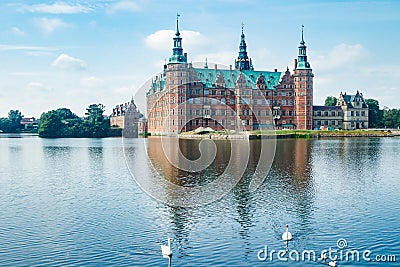View of Frederiksborg castle with white swans on lake in Hillerod, Denmark Stock Photo