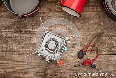 View of gas burner, spark lighter, metal dishes and cup on wooden table Stock Photo