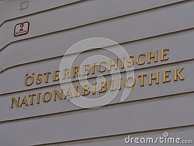 Golden lettering on white painted wall at the entrance of the Austrian National Library in the historic center of Vienna, Austria. Editorial Stock Photo