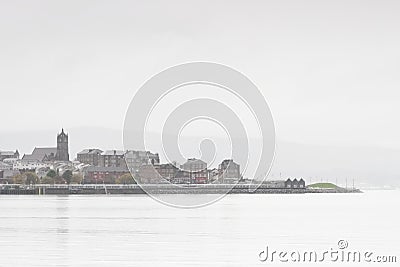 View of Gourock town in Inverclyde near Greenock in dull wet bad winter weather silhouette of village buildings and church Editorial Stock Photo