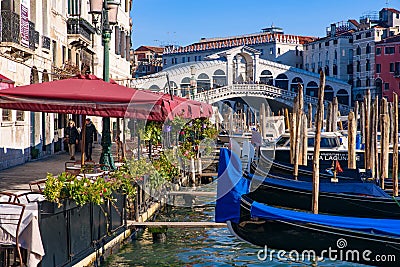 View of the Grand Canal, Rialto Bridge, and gondolas from outdoor restaurant seats, Venice Editorial Stock Photo