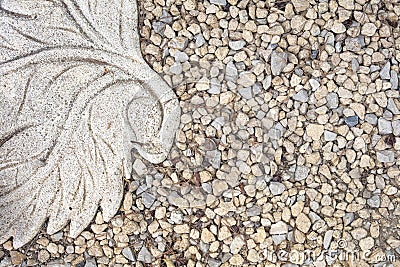 View of gravel and part of stone tile with leaf form as decoration Stock Photo