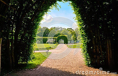 View through the green pergola into the palace gardens of Schwerin with a blue sky Stock Photo