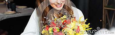 View of happy woman with bouquet of autumn flowers in cafe Stock Photo