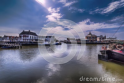 View of the harbor of Harlingen Netherlands, on a clear sunny day .To see how the cloudy clear sky reflects in the windless water Stock Photo