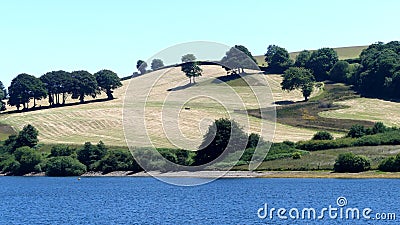 A view of hilly fields looking across Wimbleball lake in Exmoor, UK Stock Photo