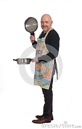 Househusband looking at a pot with food on white background Stock Photo