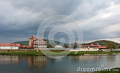 View of the houses near river Latoritsa of a small town and dark stormy dramatic clouds background, Mukachevo, Ukraine Editorial Stock Photo