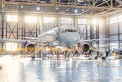 View inside the aviation hangar, the airplane mechanic working around the service Editorial Stock Photo