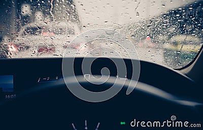View from inside car window with rain drops on glass or the windshield,Blurred traffic on rainy day in the city Stock Photo
